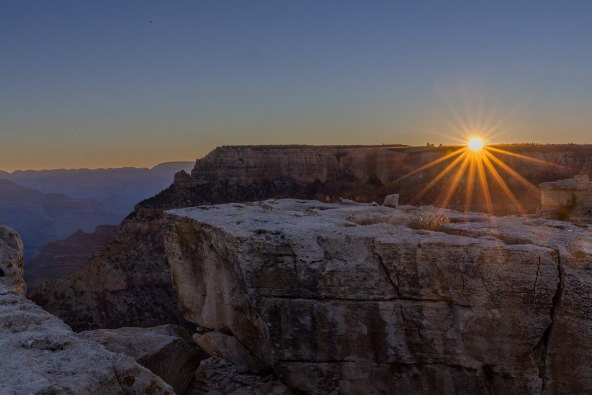 Sunrise sunstar over the Grand Canyon rim in Arizona