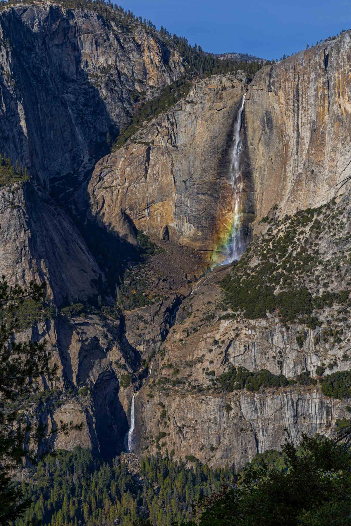 Yosemite Falls rainbow in mist with granite cliffs, Yosemite National Park