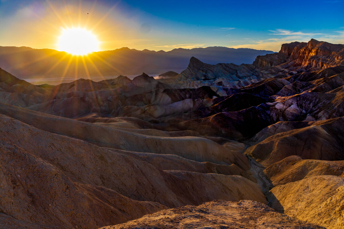 Sunrise sunburst over badlands at Zabriskie Point in Death Valley