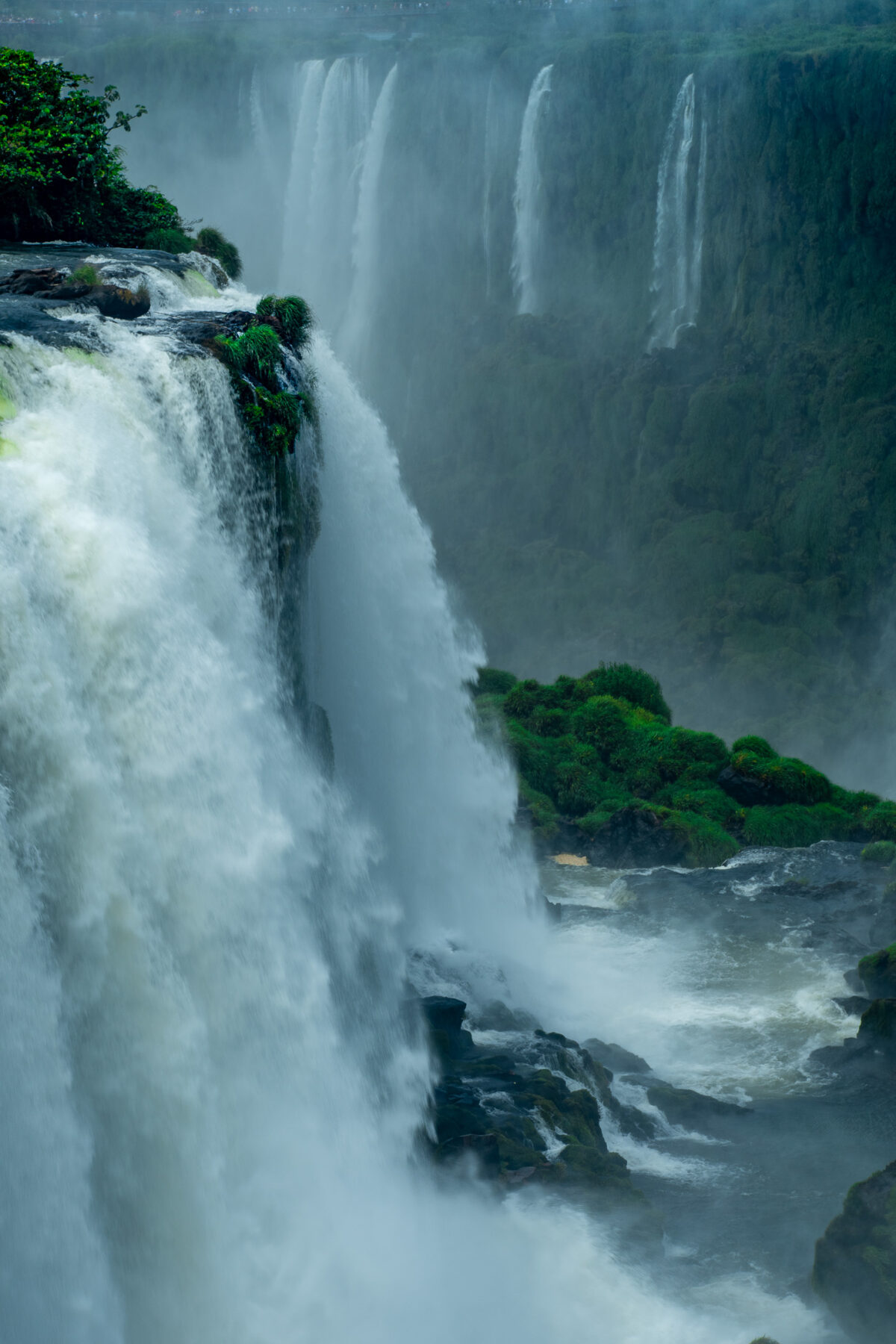 Vertical view of Iguazu Falls with cascading water, mist, and rainforest on the Argentina-Brazil border