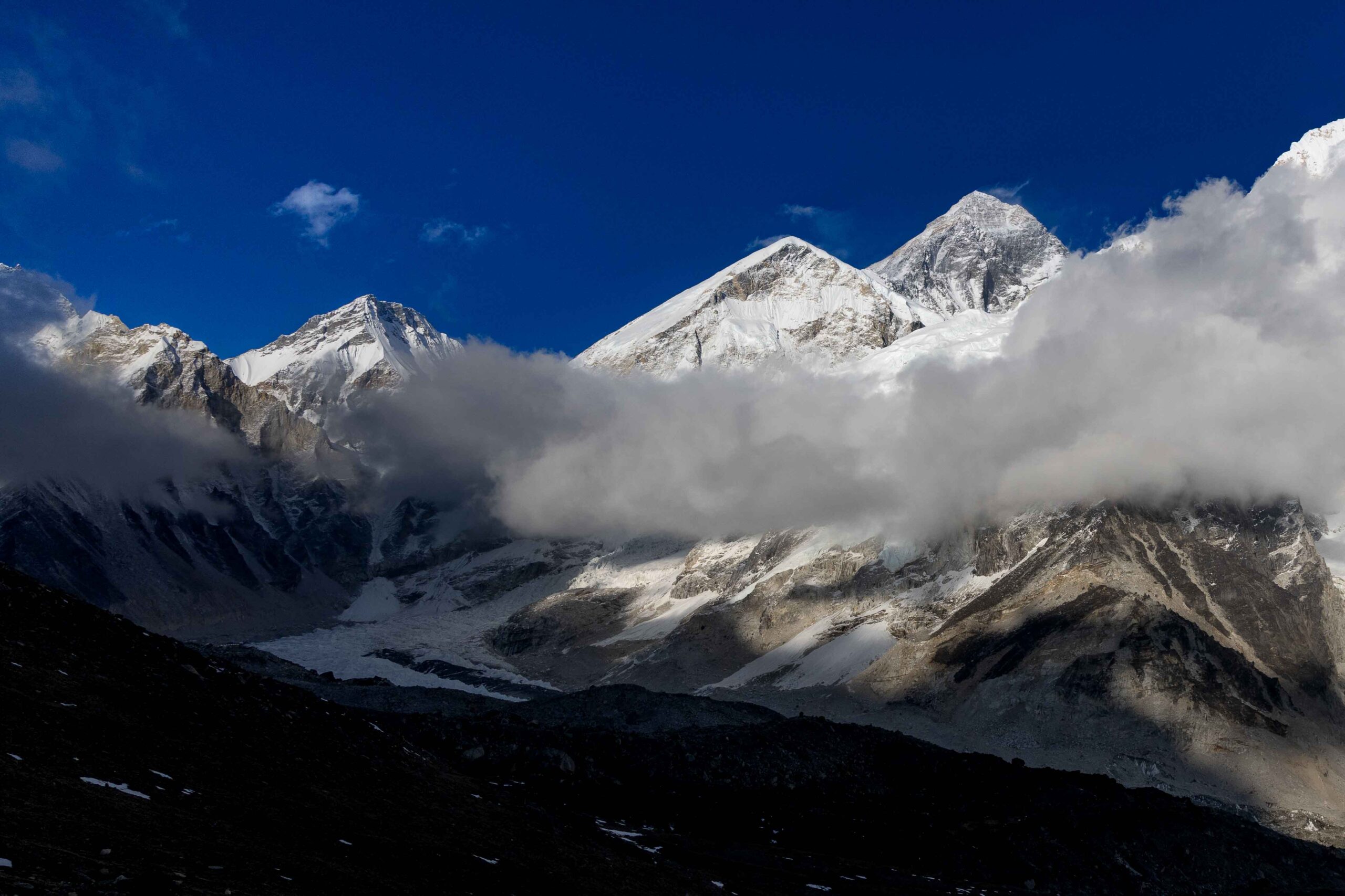 Mount Everest emerging from clouds at sunset