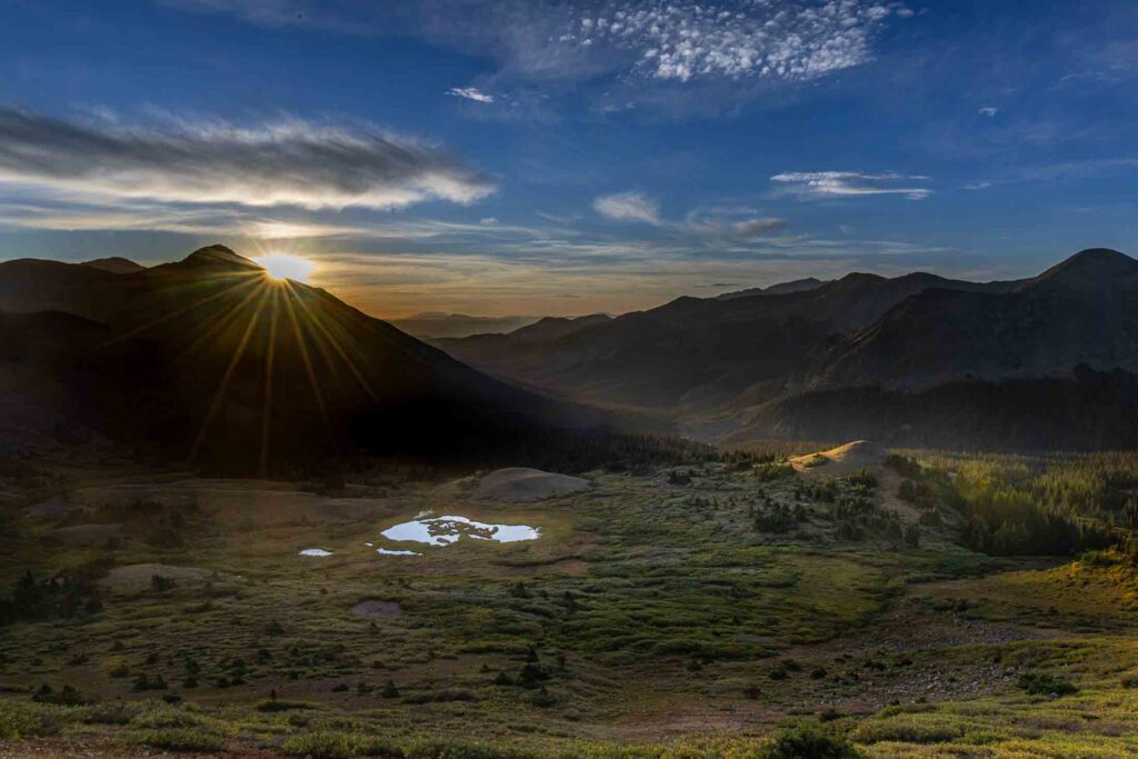Sunrise over Colorado Trail Collegiate West with a sunstar above an alpine basin in the Sawatch Range
